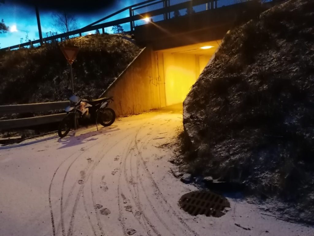 Kuvassa tunneli, talvinen ympäristö, kuvan keskellä on mopo, maassa lumessa pyörän jälkiä